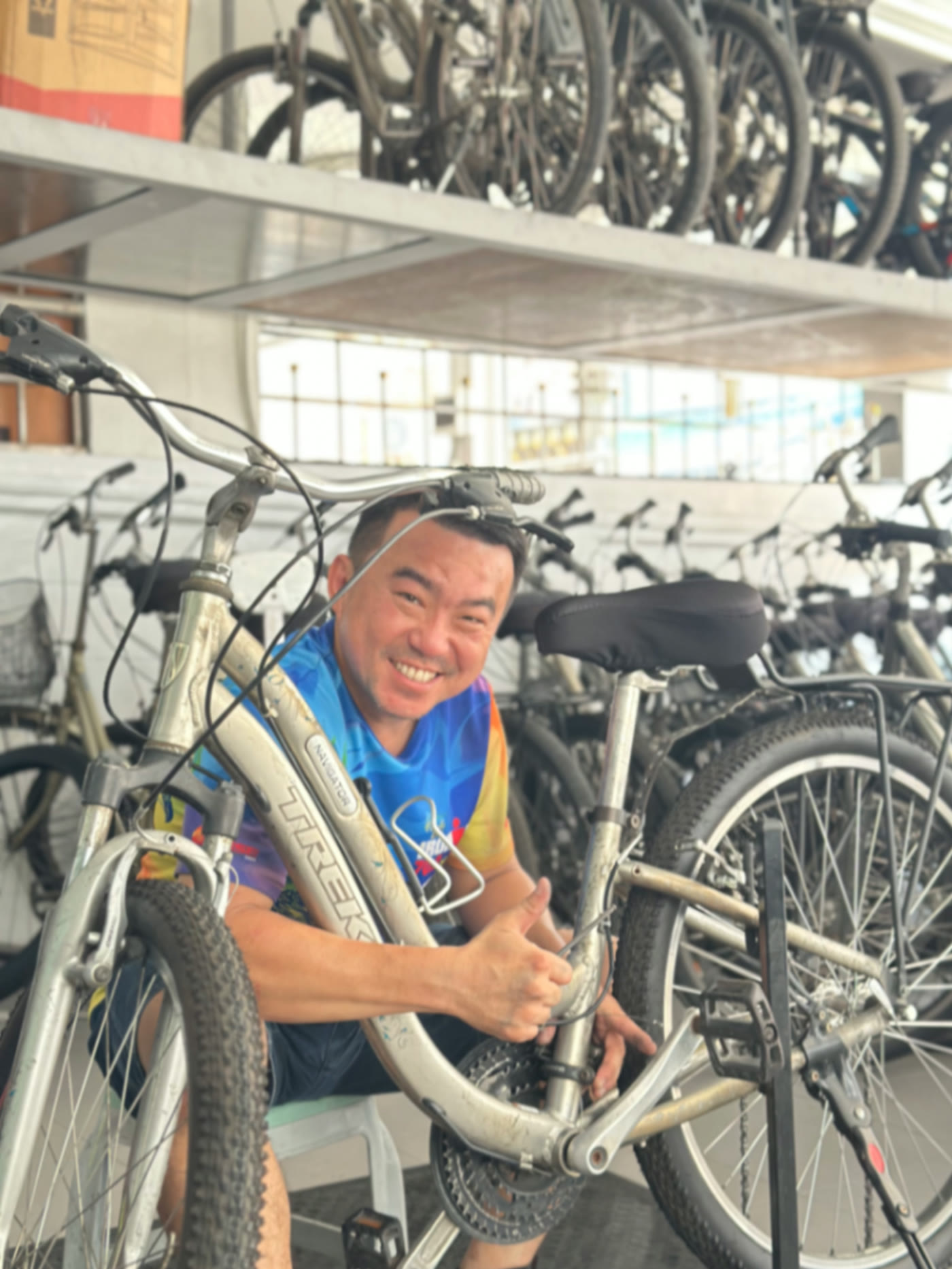 Mr. Kiattipong Boonyatnaporn, bike mechanic at ABC Bike Tours, smiling in front of the Trek bicycle fleet